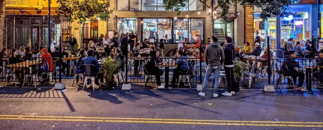 A crowd enjoys food 和 drink along San Francisco's Valencia Street